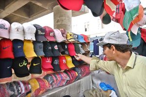 A street vendor displays caps on a cart to attract the customers at Railway Chowk in the city.