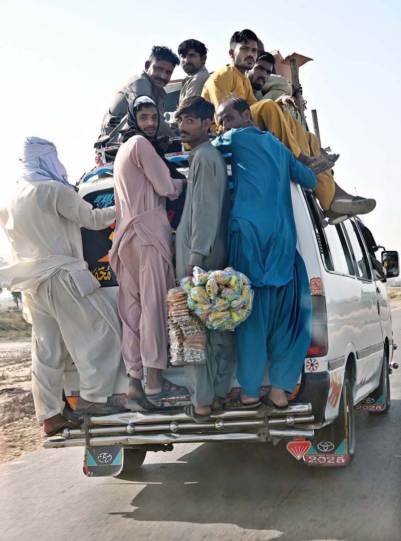 Passengers traveling on the rooftop of a van at Larkana-Dadu Road may cause any mishap and needs the attention of concerned authorities