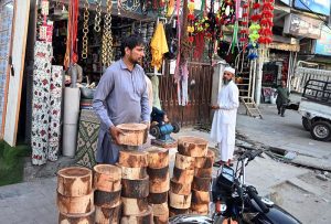 A blacksmith is busy sharpening knives and axes to be used for slaughtering sacrificial animals during Eid ul Azha