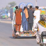 People travel while hanging on a passenger van on a busy NLC bypass road, putting their lives in risk and prompting the need for concerned authorities to take notice of the widespread violation