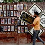 A shopkeeper are displaying calligraphy art along Blue Dome Road, attracting the attention of passersby