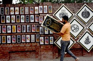 A shopkeeper are displaying calligraphy art along Blue Dome Road, attracting the attention of passersby