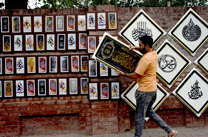 A shopkeeper are displaying calligraphy art along Blue Dome Road, attracting the attention of passersby