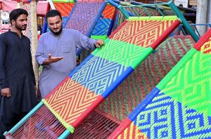 A boy busy in preparing traditional bed (Charpai) at his workplace.