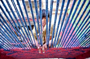 A boy busy in preparing traditional bed (Charpai) at his workplace.