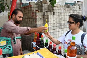 A vendor busy in preparing and selling Ice Gola to the customers on the roadside setup