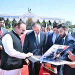 Dr. Tariq Fazal Chaudhry, Federal Minister for Parliamentary Affairs, presents a photo album to His Highness Prince Rahim Aga Khan upon his departure from Islamabad