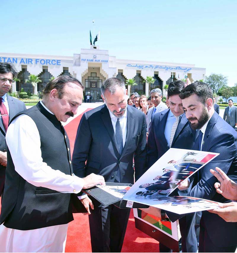 Dr. Tariq Fazal Chaudhry, Federal Minister for Parliamentary Affairs, presents a photo album to His Highness Prince Rahim Aga Khan upon his departure from Islamabad
