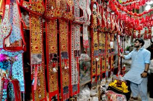 A vendor arranges decorative accessories for sacrificial animals at a local market in preparation for Eid al-Azha.