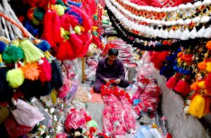 A vendor arranges decorative accessories for sacrificial animals at a local market in preparation for Eid al-Azha.