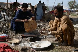 Livestock vendors are watering sacrificial camels while waiting for customers at a temporary cattle market in Shahpur Kanjra ahead of Eid-ul-Azha