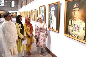 Visitors keenly viewing paintings on display marking the first anniversary of “Marka-e-Haq,” and the Successful operation Bunyan-al-Marsoos at NCA.