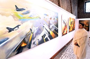 Visitors keenly viewing paintings on display marking the first anniversary of “Marka-e-Haq,” and the Successful operation Bunyan-al-Marsoos at NCA.