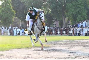 A horse rider aims his target during tent pegging at the opening ceremony of the All Pakistan Universities Football Championship hosted by the University of Sargodha.