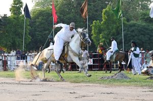 A horse rider aims his target during tent pegging at the opening ceremony of the All Pakistan Universities Football Championship hosted by the University of Sargodha.