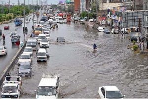 Vehicles passing through rainwater accumulated at IJP Road during heavy rain in the Federal Capital.