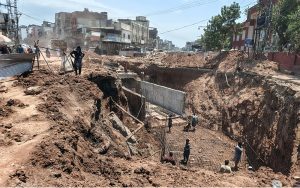 Workers and heavy machinery carry out construction work near Gunj Mandi, as the project progresses to ease traffic congestion and improve the city's road infrastructure