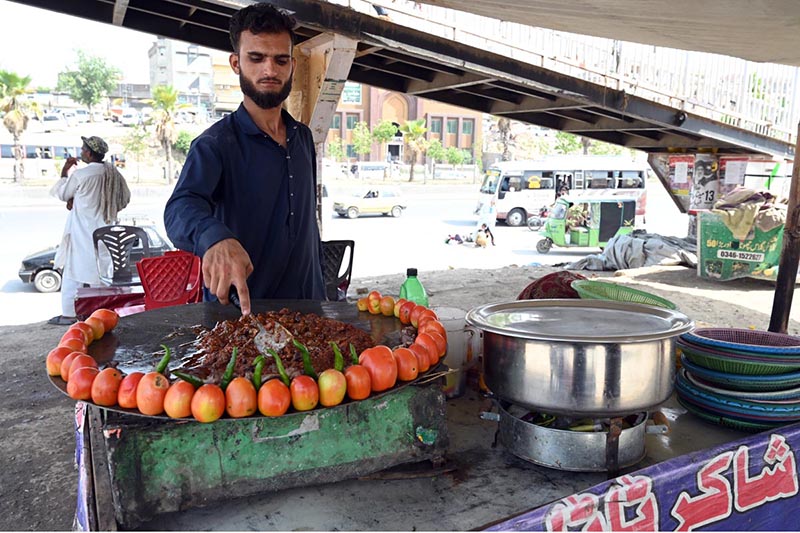 A vendor busy in frying ‘Tawa Kaleji’ for customers at his roadside setup in the Federal Capital