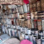 A vendor arranges a vast collection of carpets and rugs of various designs, patterns and sizes at a carpet shop in weekly bazaar H-9, Federal Capital