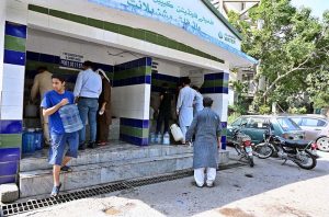 People filling their pots with clean drinking water from filtration plant during hot weather in the Federal Capital.