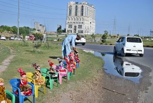 A vendor displaying colorful dolls to attract the customers along roadside at PWD Interchange.