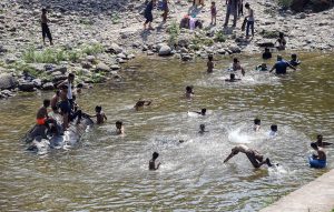 A large number of people, including children and youngsters, cool off by swimming and playing in Korang Nullah, as an intense heat wave continues to grip the region driving residents to seek refuge in natural water bodies.