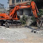 A excavator breaks through road surface during sewerage pipeline installation work on IJP Road