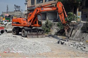 A excavator breaks through road surface during sewerage pipeline installation work on IJP Road