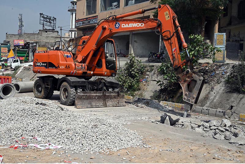 A excavator breaks through road surface during sewerage pipeline installation work on IJP Road