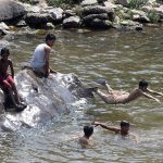Youngsters dive and swim in Korang Nullah to seek relief from the scorching summer heat