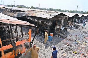 Vendors gather their salvaged goods amid the aftermath of a devastating fire that swept through the weekly H-9 Bazaar near Peshawar Mor in the Federal Capital, leaving numerous shops damaged and traders counting their losses.