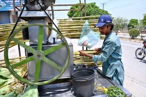 A vendor prepares sugarcane juice to attract customers during scorching heat in the Federal Capital.