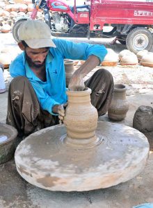 A craftsman is busy preparing clay-made stuff at his workplace in Kumhar para.