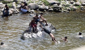 Youngsters dive and swim in Korang Nullah to seek relief from the scorching summer heat