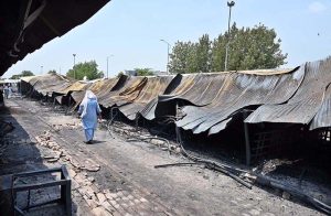 Vendors gather their salvaged goods amid the aftermath of a devastating fire that swept through the weekly H-9 Bazaar near Peshawar Mor in the Federal Capital, leaving numerous shops damaged and traders counting their losses.