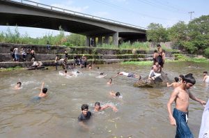 A large number of youngsters swim and splash in the Rawal Lake spillway waters to seek relief from the intense summer heat in the federal capital. The spillway has become a popular spot for young citizens looking to cool off as temperatures soar across Islamabad during the ongoing heat wave season