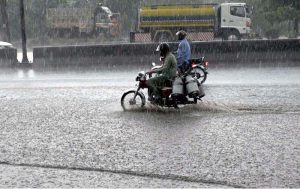 Vehicles passing through rainwater accumulated at IJP Road during heavy rain in the Federal Capital.