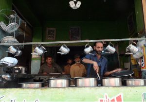 Workers prepare food at a traditional roadside dhaba restaurant; as such eateries continue to serve affordable meals to residents and labourers across the city