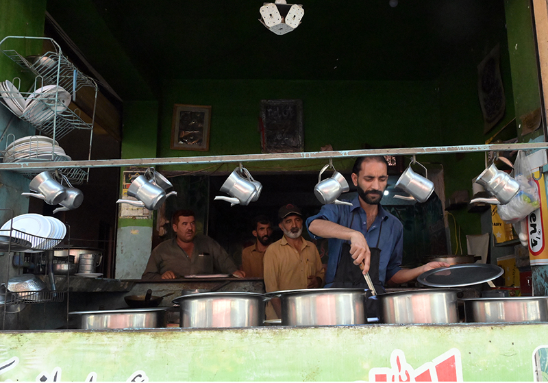 Workers prepare food at a traditional roadside dhaba restaurant; as such eateries continue to serve affordable meals to residents and labourers across the city