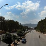 Clouds hover over the Margalla Hills as vehicles make their way along a Expressway in the Federal capital