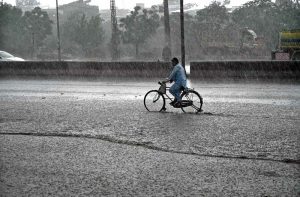 Vehicles passing through rainwater accumulated at IJP Road during heavy rain in the Federal Capital.