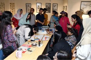 Chinese calligraphy artist Jiang Lin Zitong demonstrates the art of traditional Chinese calligraphy during a special workshop titled “Enduring Culture, Profound Friendship” at the Shakir Ali Museum, commemorating the 75th anniversary of diplomatic relations between Pakistan and China