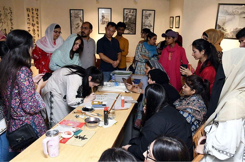 Chinese calligraphy artist Jiang Lin Zitong demonstrates the art of traditional Chinese calligraphy during a special workshop titled “Enduring Culture, Profound Friendship” at the Shakir Ali Museum, commemorating the 75th anniversary of diplomatic relations between Pakistan and China
