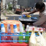 A vendor prepares chilled gola ganda at a roadside cart, as demand for cold and refreshing beverages surges amid the scorching summer heat gripping the city