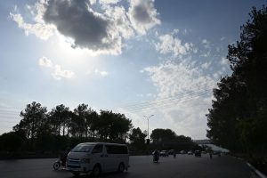 Clouds hover over the Margalla Hills as vehicles make their way along a Expressway in the Federal capital