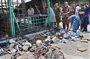 Vendors gather their salvaged goods amid the aftermath of a devastating fire that swept through the weekly H-9 Bazaar near Peshawar Mor in the Federal Capital, leaving numerous shops damaged and traders counting their losses.