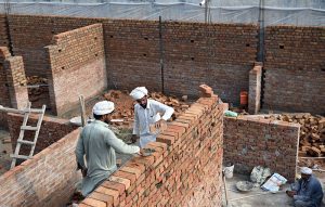 Masons brave the scorching summer heat as they carry out brickwork on a building under construction in the federal capital. The daily wage construction workers continue their labour under severe heat conditions.