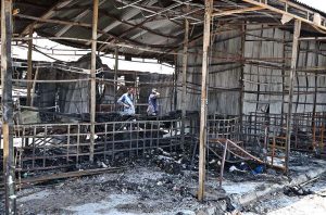 Vendors gather their salvaged goods amid the aftermath of a devastating fire that swept through the weekly H-9 Bazaar near Peshawar Mor in the Federal Capital, leaving numerous shops damaged and traders counting their losses.