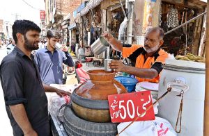 A vender prepares and sell traditional drink lassi to attract customers at Muslim bazaar.