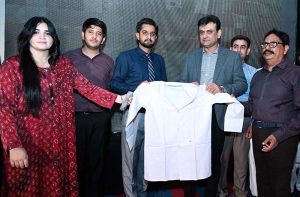 Deputy Commissioner Tariq Manzoor Chandio distributes ceremonial white coats to newly admitted DPT and BS Nursing students during the Orientation and White Coat Ceremony at Chandka Institute of Nursing and Allied Health Sciences